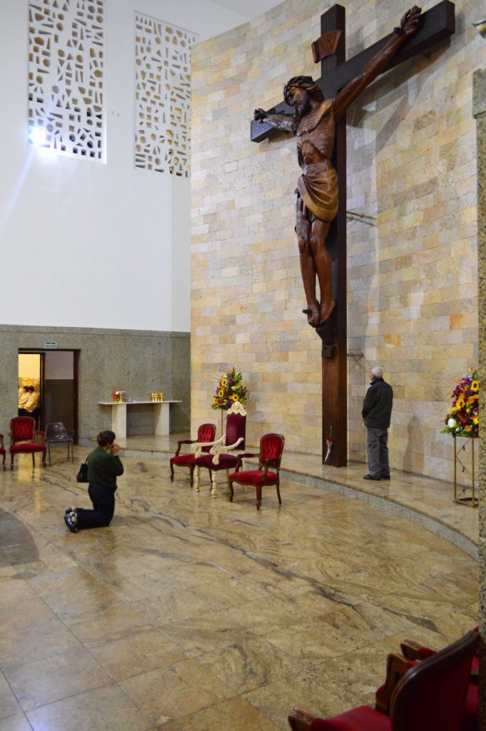 A cruz do nosso Santuário A grande cruz de madeira do presbitério da igreja nova foi feita especialmente para o Santuário em 1970. É uma obra do escultor austríaco Hans Bachler, de Treze Tilhas (SC). O corpo de Cristo, uma tora inteiriça de madeira de cedro, mede 4,35m de altura; pesando 800 kg; está preso à cruz de 11m.  O trabalho é entalhado à mão, sem uso de maquinário, apenas talhadeiras manuais e formões.